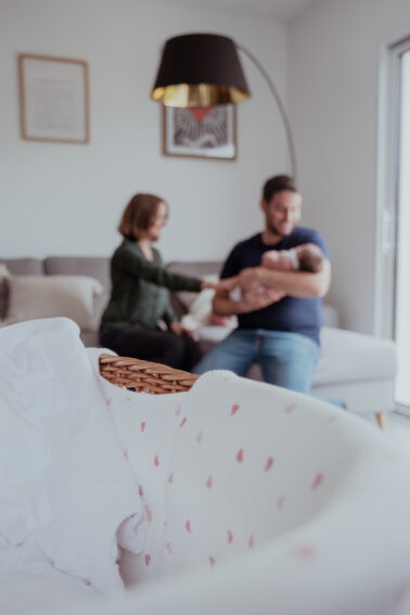 berceau premier plan avec famille nouveau-né arrière-plan