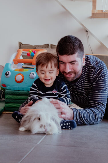 enfant et papa jouent avec lapin salon