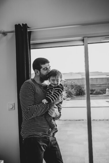 père avec enfant dans bras sourire
