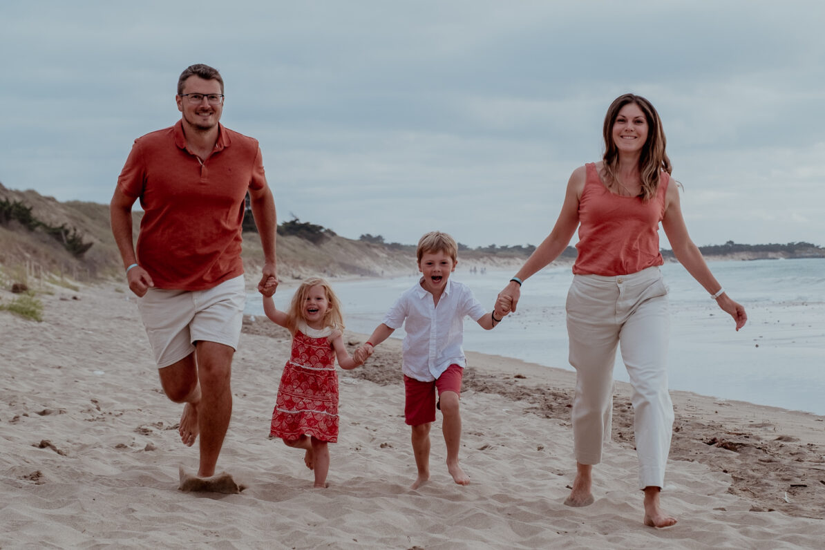 famille quatre personnes dress code blanc terra cotta plage mains dans mains