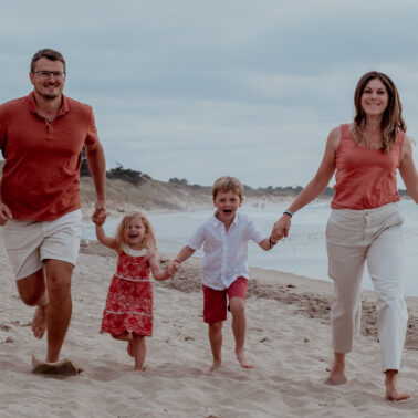 famille quatre personnes dress code blanc terra cotta plage mains dans mains