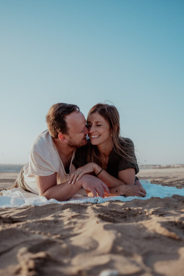 couple complicité allongés sable plage