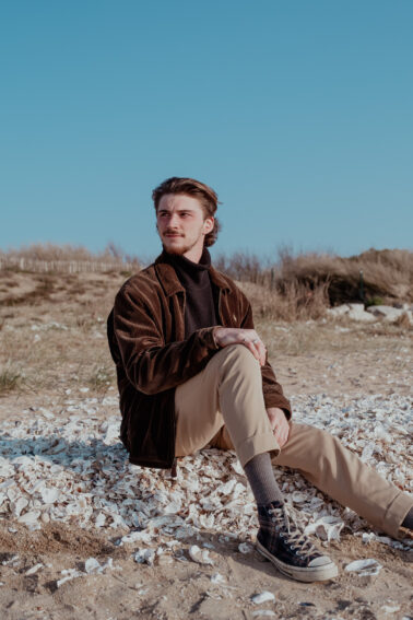 jeune homme modèle plage assis