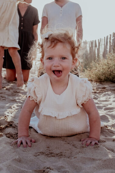 petite fille tire langue allongée sable