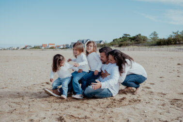 famille assise sable plage cinq personnes