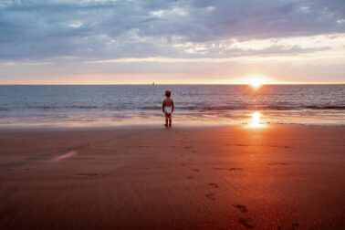 bébé en couche face à la mer coucher de soleil