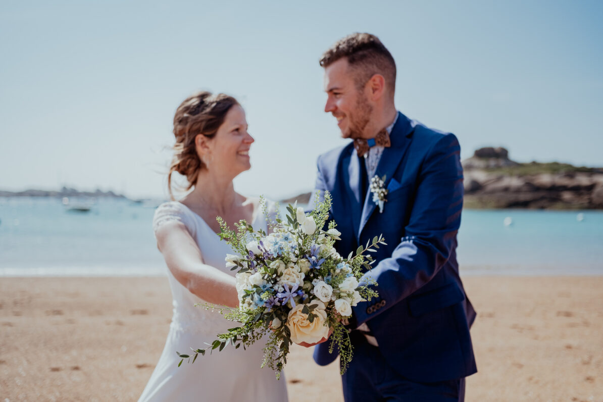 couple se regardant bouquet de fleurs plage mer