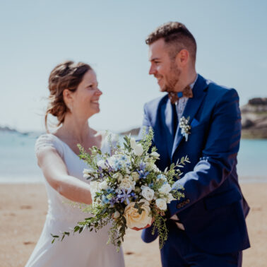 couple se regardant bouquet de fleurs plage mer