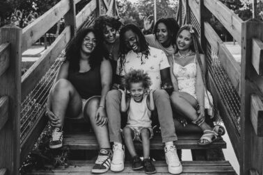 rires complicité sourires grande famille assise pont bois