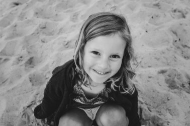 petite fille assise sable portrait