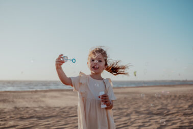 faire des bulles à la plage petite fille