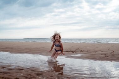 petite fille s'amuse saute dans l'eau mer plage